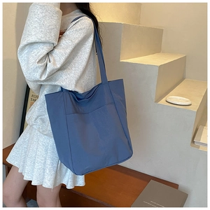 Detail of blue-purple large capacity tote bag with outer pocket and minimalist stitching