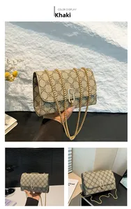 Macro shot of khaki shoulder bag featuring clover pattern and gold ball chain detail