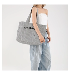 Grand sac cabas à rayures verticales et imprimé summer porté par un mannequin