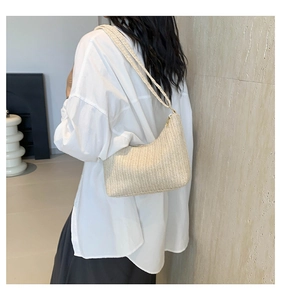 Détail d'un sac hobo tressé beige montrant la texture diagonale fine et les doubles bretelles