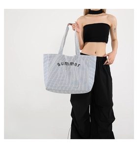 Detail of blue striped canvas tote bag with black Summer embroidery and shoulder straps