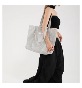 Vue détaillée du grand sac cabas en toile rayée avec inscription Summer portée par un mannequin