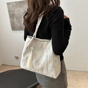 Grande borsa tote bianca retrò con ricami colorati e nappa su una modella femminile
