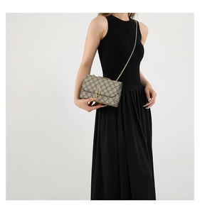 Detailed view of vintage crossbody bag with gold chain strap on model in white studio