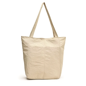 Lightweight nylon tote bag with dual shoulder straps and front pockets in beige color