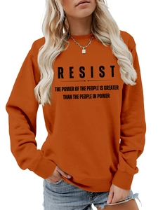 Detailansicht von geripptem Rundhalsausschnitt und schwarzem RESIST-Slogan auf orangefarbenem Hoodie