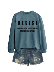 Detail eines blaugrünen Sweatshirts mit Resist-Aufdruck und Jeans-Shorts auf weißem Grund