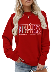 Détail d'un sweat rouge à col rond avec le slogan Kindness is Free imprimé en couleur