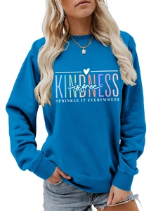 Détail du sweat bleu roi montrant le lettrage Kindness Is Free et les poignets côtelés