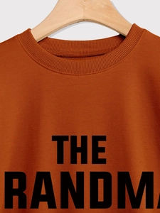 Détail du sweat-shirt col rond marron caramel avec texte noir The Grandma en gras