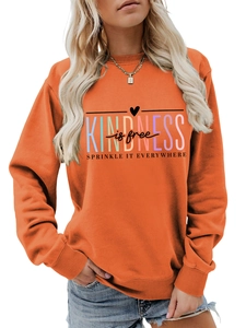 Détail d'un sweat orange vif avec le slogan Kindness is free imprimé en couleurs