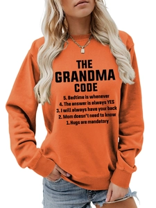 Détail du sweat orange à col rond avec texte imprimé noir The Grandma Code