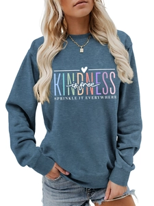 Gros plan sur l'imprimé Kindness is Free coloré sur un sweat à manches longues bleu