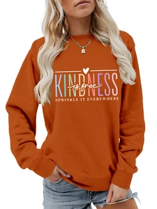 Détail du sweat-shirt orange caramel avec slogan coloré Kindness is free imprimé