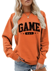 Détail du sweat-shirt orange montrant l'imprimé Game Day et les poignets côtelés