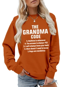 Détail du texte THE GRANDMA CODE sur sweat-shirt orange à manches longues et col rond côtelé