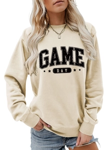 Détail du motif Game Day et des étoiles sur le sweat à col rond couleur abricot