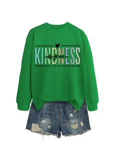 Détail de l'imprimé Kindness Is Free sur sweat vert et short en jean vieilli