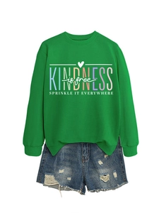 Détail d'un sweat vert avec imprimé Kindness is Free coloré et finitions de poignets côtelés