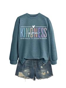 Détail du sweat-shirt bleu canard avec texte coloré Kindness is free et finitions côtelées