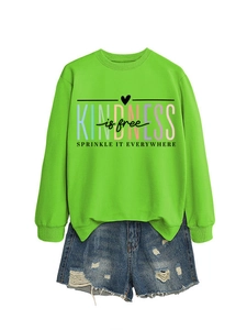 Détail d'un sweat vert néon avec imprimé 'KINDNESS is free' et poignets côtelés