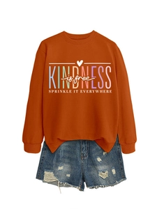 Détail de l'imprimé Kindness Is Free sur un sweat à col rond de couleur orange brûlé
