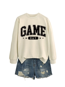 Vue à plat du sweat blanc cassé Game Day avec étoiles et short en jean vieilli