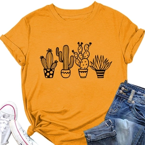T-shirt giallo senape con grafica cactus, jeans e scarpe bianche in posa piatta