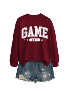 Gros plan sur l'imprimé usé Game Day et l'étoile sur le sweat-shirt rouge foncé