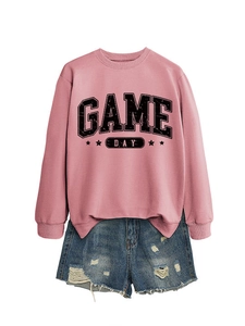 Détail du sweat à col rond rose avec imprimé Game Day et short en jean usé
