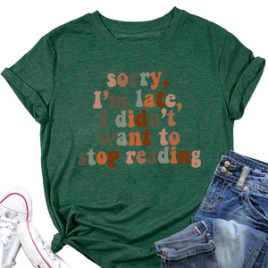 Flat lay of green round neck T-shirt with 'sorry I'm late' quote and denim jeans