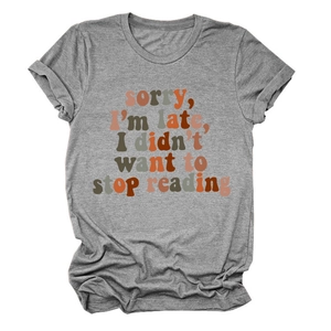 Close-up of grey short-sleeve T-shirt with gradient text print on plain background