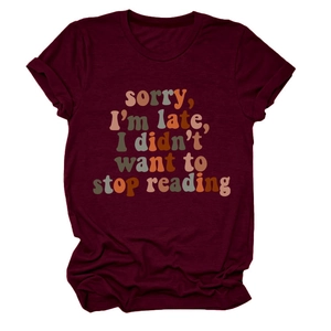 Flat lay of maroon crewneck t-shirt with sorry i'm late i didn't want to stop reading print