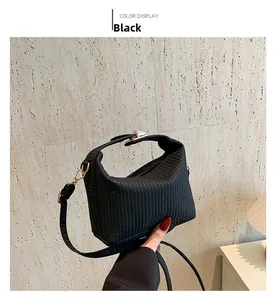 Detailansicht der schwarzen kleinen Tasche mit Webstruktur und Goldbeschlägen