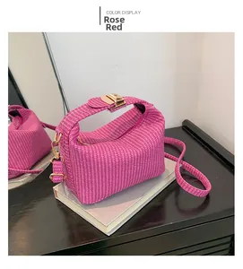 Detail der rosaroten geflochtenen Handtasche mit goldenen Beschlägen auf Büchern