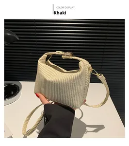 Detail der khakifarbenen gewebten Handtasche mit goldenem Druckschloss und Schultergurt