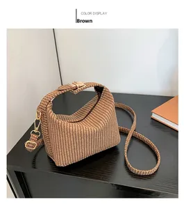 Detail einer braunen Trapez-Handtasche mit Hahnentrittmuster und Goldverschluss