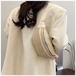Détail du sac ceinture en paille tressée avec bordure en cuir et zip en métal
