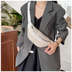 Détail d'un sac banane tissé crème avec bandoulière en nylon portée par un mannequin