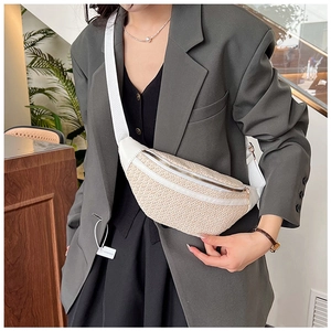 Détail du sac de poitrine tissé beige avec garniture en cuir blanc et fermeture éclair