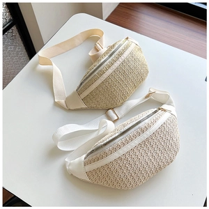 Détail de sacs banane en paille tressée beige et blanc avec bandoulière réglable
