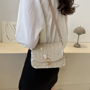 Straw texture crossbody bag featuring pink floral embroidery and metallic gold buckle