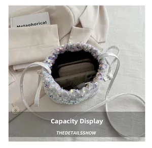 Internal capacity display of a white sequin drawstring bucket bag with mobile and lipstick