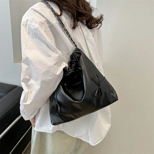 Minimalist black pleated bucket bag with chain strap and bow details for women