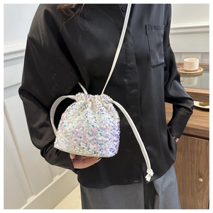 Detail of white sequin bucket bag with colorful iridescent sparkles and drawstring close