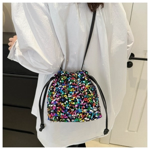 Detail of colorful sequin drawstring bucket bag with black thin shoulder strap and tassels