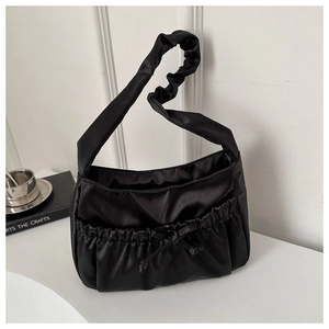 Detail of black satin ruched shoulder bag with drawstring bow and scrunchie strap
