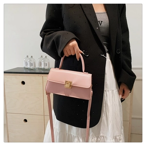 Detail der rosa Lederhandtasche mit quadratischem goldenem Metalldrehverschluss und Textur