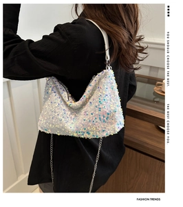 Detail of white sequin shoulder bag showing shimmering texture and silver chain strap