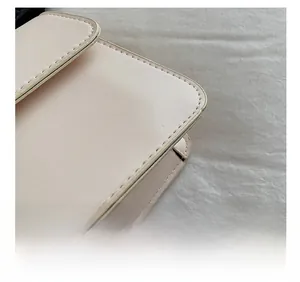 Dettaglio ravvicinato delle cuciture precise sulla borsa a spalla in pelle beige